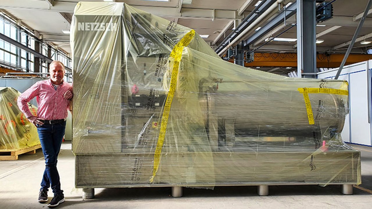 A machine wrapped in ICB film. Standing next to it is Hans-Jürgen Glettner, Operations Manager at Netzsch-Feinmahltechnik GmbH in Selb