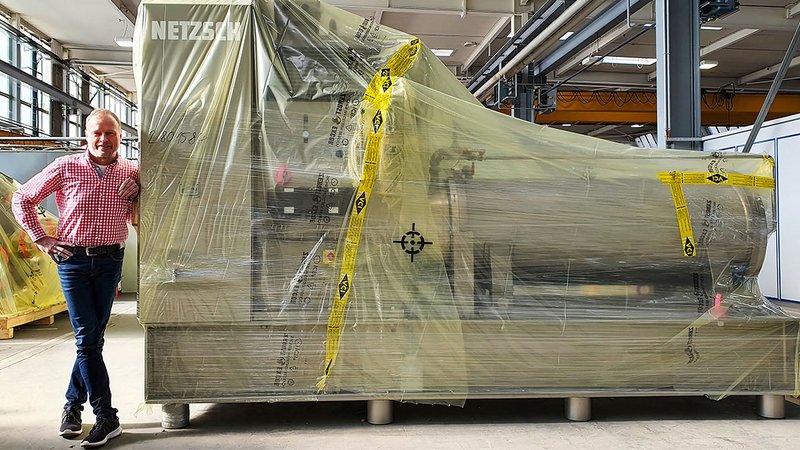 ICB Testimonial Netzsch A machine wrapped in ICB film. Next to it is Hans-Jürgen Glettner, Operations Manager of Netzsch-Feinmahltechnik GmbH in Selb